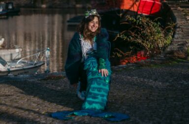 Smiling person sat wearing a mermaid tail