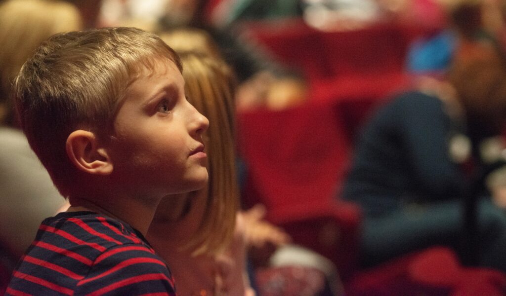 A young boy looks towards the stage.